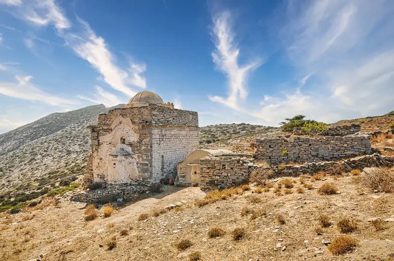 Ancient Episkopi church and old walls on a hillside in Sikinos island Greece