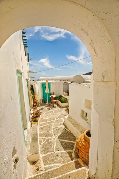 Arched passage and stone path leading into a courtyard in Kastro on Sikinos