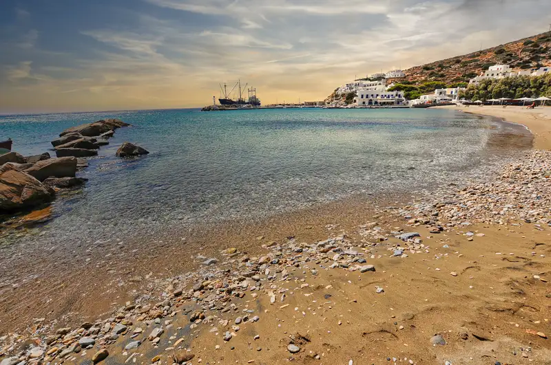 The sandy beach and bay of Alopronia port in Sikinos with rocks and clear water