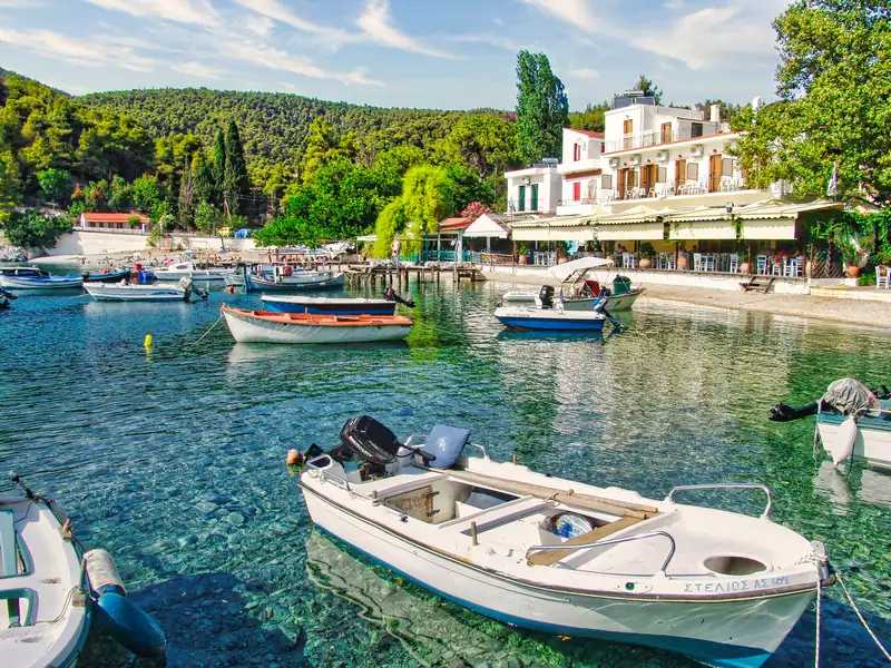 The harbour of Agnontas with traditional boats and a waterside taverna on Skopelos