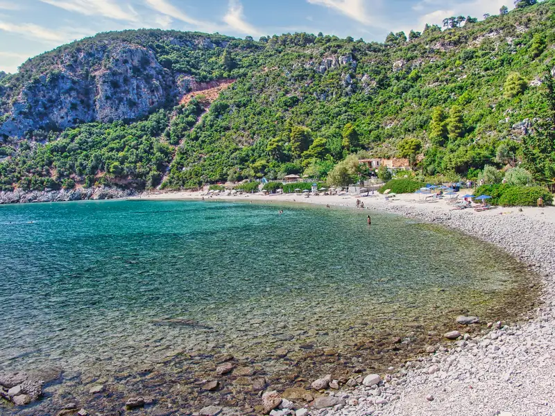 The pebble shore and clear water of Limnonari beach on Skopelos island