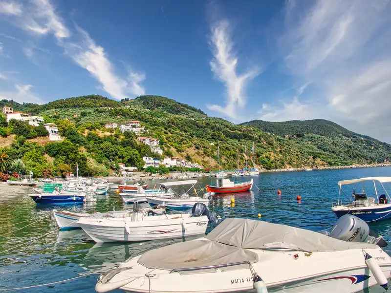 The boats of Loutraki resting below the green hills of Skopelos