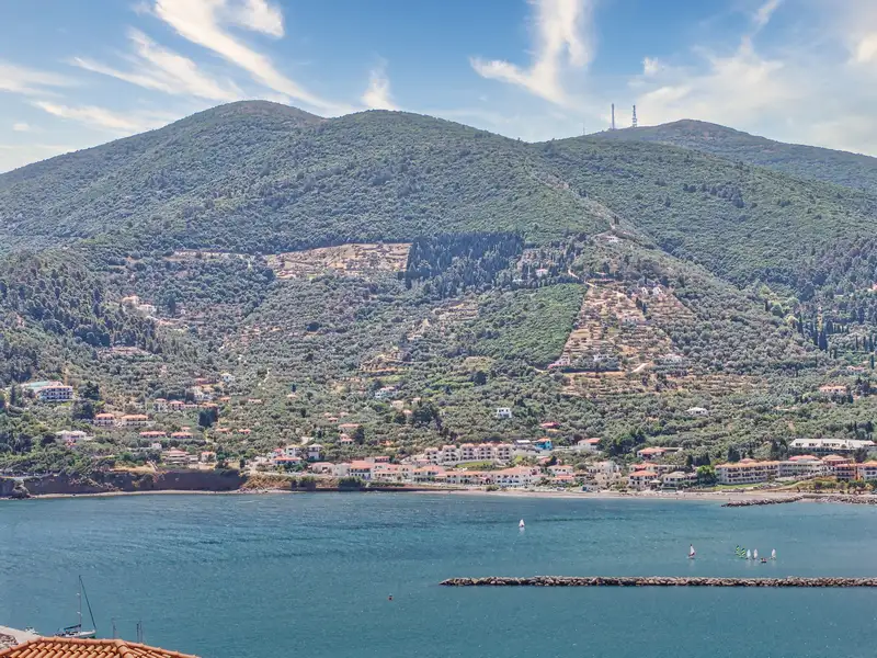 The green slopes of Skopelos rising above a sheltered shore and breakwater