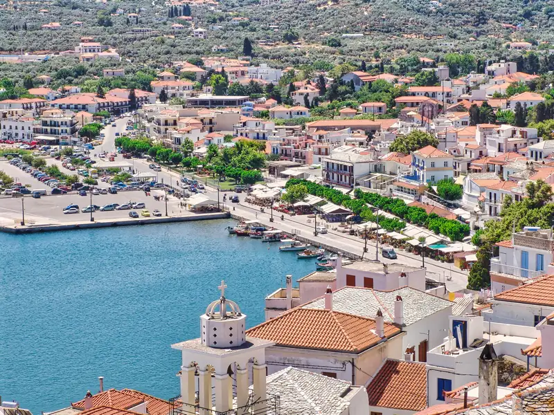 Terracotta roofs and a whitewashed church above the port of Skopelos town