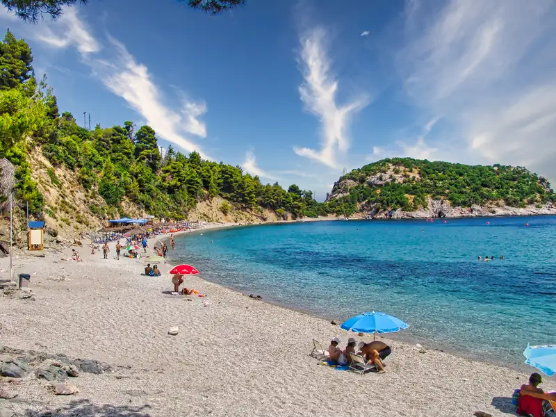 The curved bay of Stafylos beach below green headlands on Skopelos