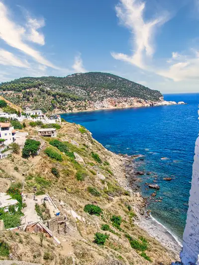 Whitewashed houses above the cliffs and sea on the coast of Skopelos island