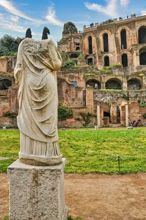 Ancient marble statue and the ruins of the Roman Forum on Palatine Hill in Rome, Italy