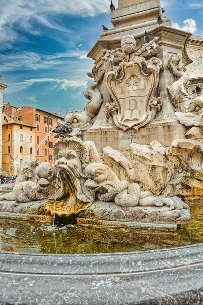 The carved mask and dolphins of the Fontana del Pantheon spouting water, Rome