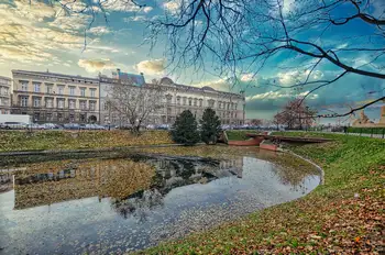 Historic palace beside a calm pond with autumn trees in a park in Wroclaw