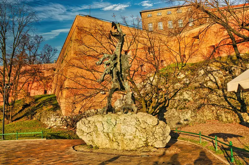 Wawel Dragon sculpture on a limestone rock below the castle walls in Krakow