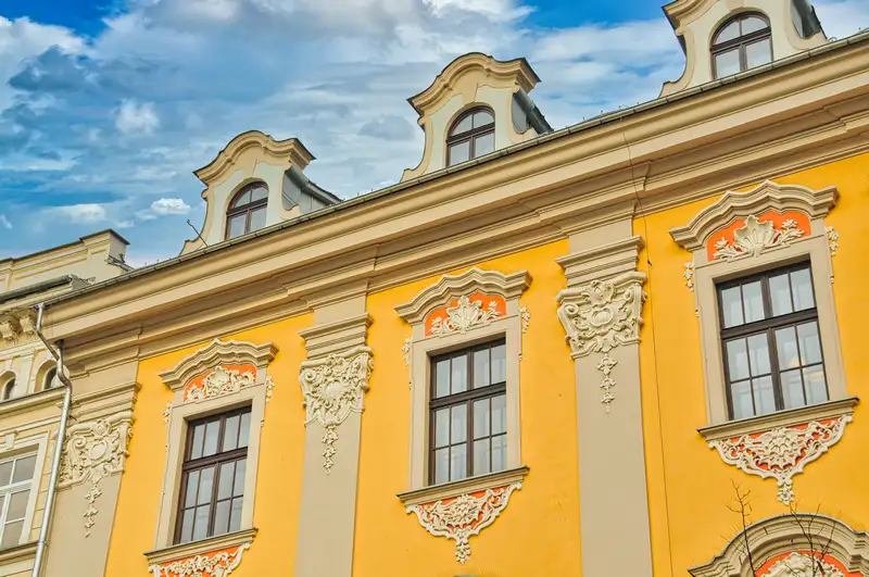 Yellow baroque facade with white stucco decoration in Krakow, Poland