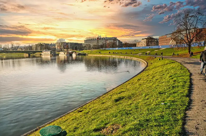 Walking path along the Vistula riverbank in Krakow with the city beyond