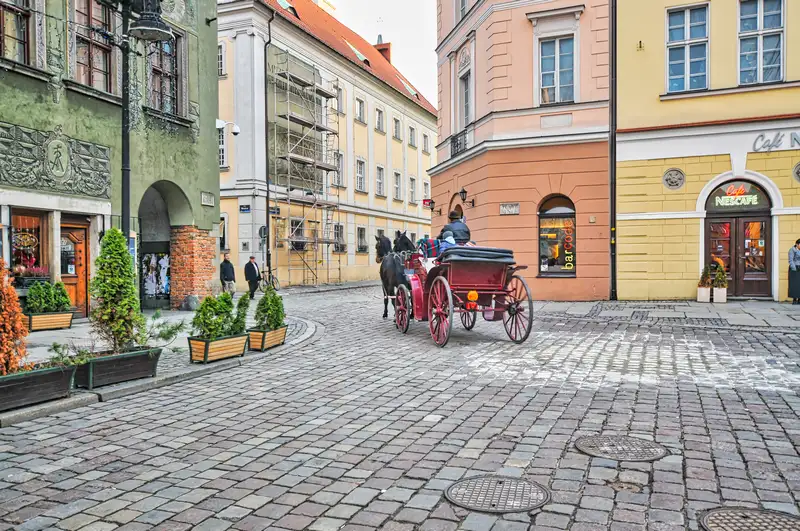 Horse drawn carriage crossing the cobbles of Poznan Old Market Square