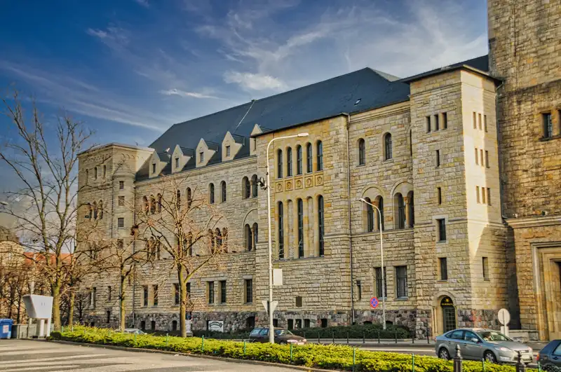 Imperial Castle in Poznan seen from the street with bare trees in front