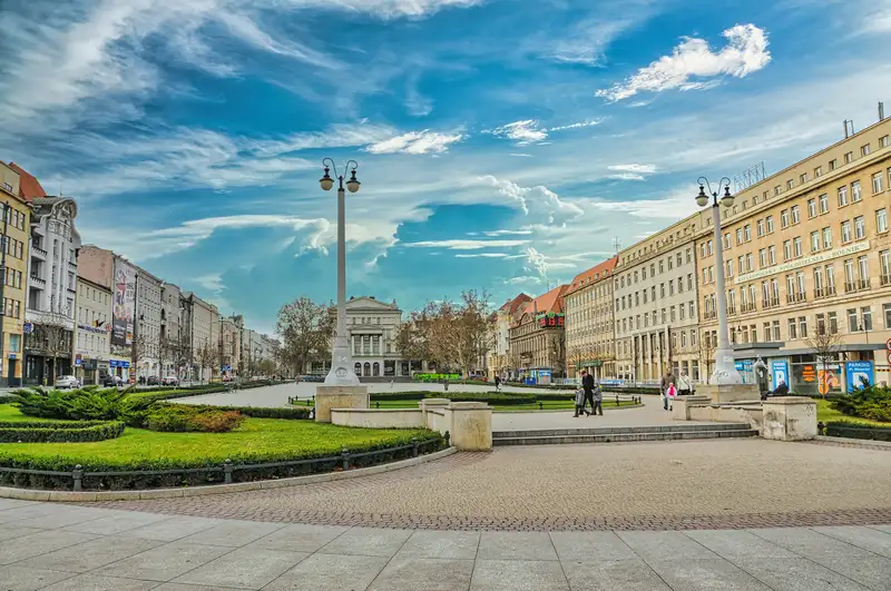Plac Wolnosci in Poznan with tall lamp columns and city buildings