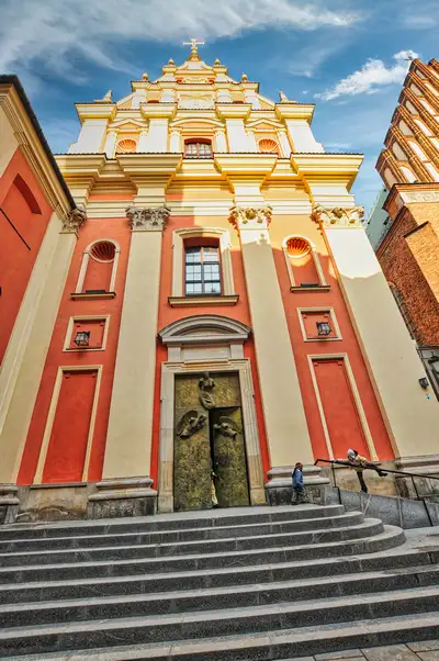 Red and cream facade of the Jesuit Church on Świętojańska Street in Warsaw