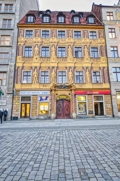 Golden baroque façade with carved statues in Wroclaw